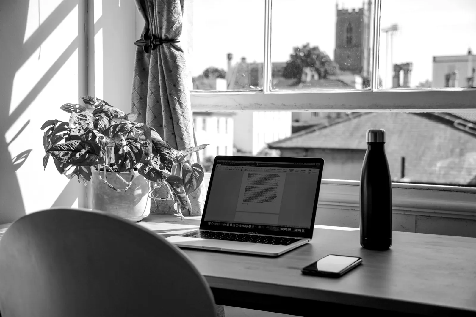 Arbeitsplatz mit Laptop am Fenster in Schwarzweiß