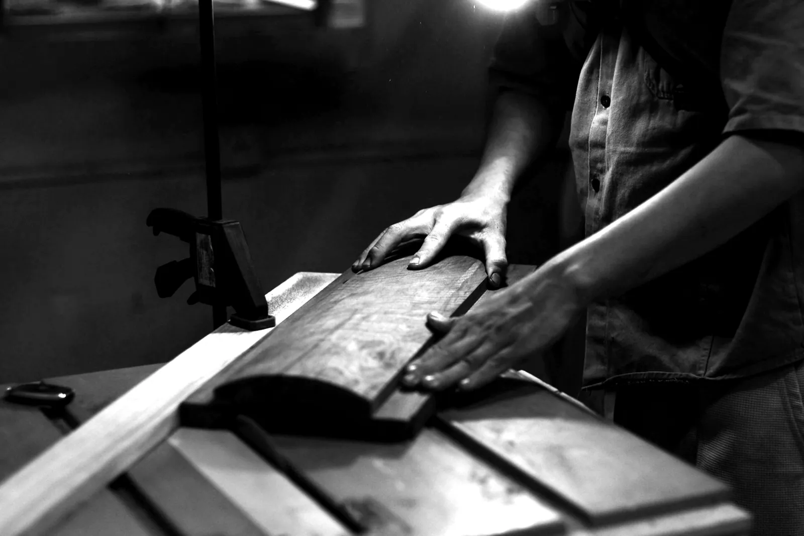 Hände eines Handwerkers bearbeiten ein Holzbrett in der Werkstatt