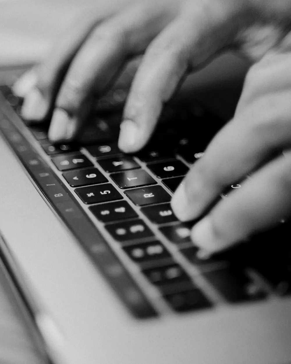 Hände tippen auf einer Laptop-Tastatur